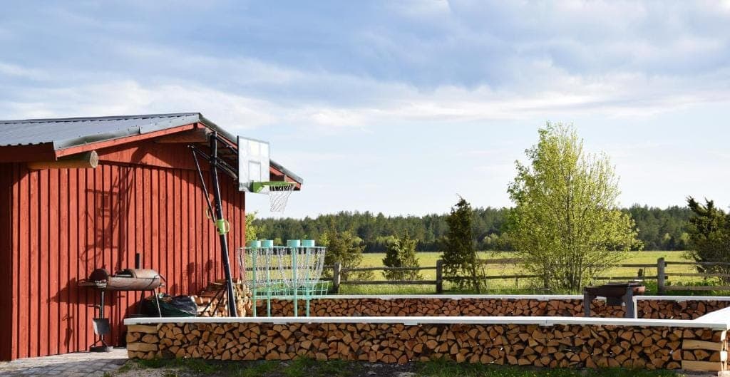 Grill, discgolfi korvid ja küttepuude sein Ratturi Talu õuel
